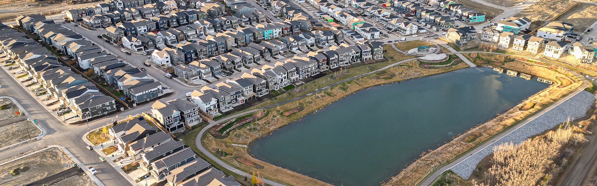 Aerial view of a Vermilion Hill neighborhood surrounding a pond with walking paths and landscaped green space.